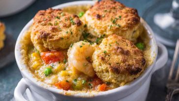 Golden Cheddar Bay biscuits baked over a creamy seafood pot pie filling with shrimp, crab, and vegetables, served in a rustic casserole dish.