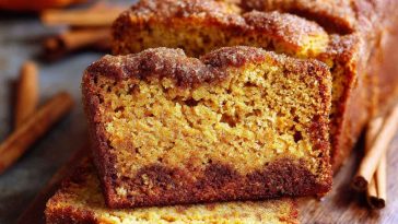 Snickerdoodle pumpkin bread loaf with a golden cinnamon-sugar crust, sliced to show moist interior.