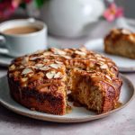 A slice of healthy oatmeal apple cake with chunks of fresh apple, topped with oats and cinnamon, served on a rustic plate.