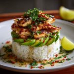 Honey lime chicken & avocado rice stack layered with grilled chicken, fluffy rice, creamy avocado, and fresh cilantro, drizzled with honey lime glaze and served in a stacked presentation.