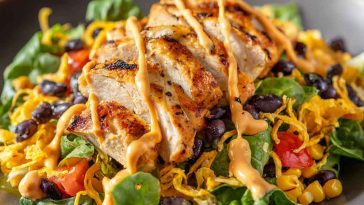 A vibrant bowl of Southwest chicken salad with grilled chicken, black beans, corn, avocado, and a zesty lime dressing.