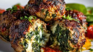 Golden-browned meatballs stuffed with melted mozzarella, flecked with spinach and garlic, served with marinara sauce and fresh basil.