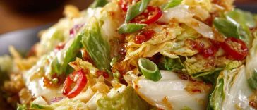 Salad Frito Cowboy Cabbage with shredded cabbage, ground beef, tomatoes, cheese, and crunchy Fritos, tossed in a zesty dressing and served in a large bowl.