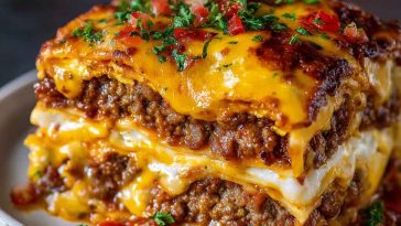 Layered casserole of cheesy ground beef, pasta sheets, and burger-inspired toppings baked to golden perfection.