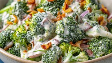 Creamy broccoli ranch salad with bacon, cheddar, and sunflower seeds in a white bowl.