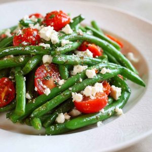 Golden baked parmesan-crusted chicken breasts with a crispy breadcrumb and cheese coating, garnished with parsley and served with lemon wedges.