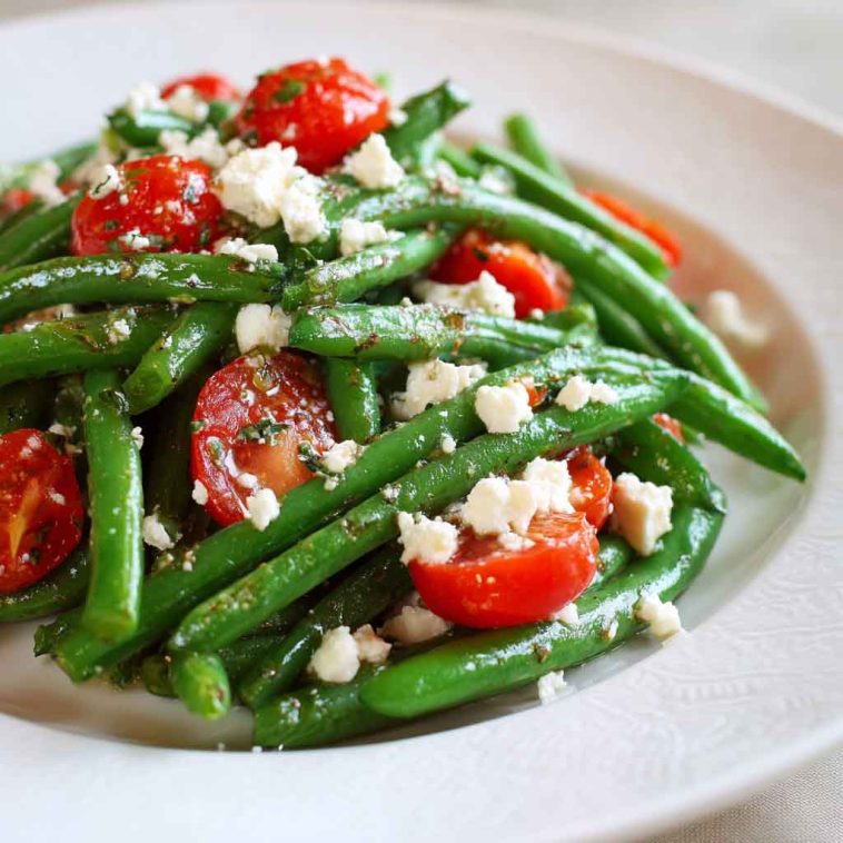 Golden baked parmesan-crusted chicken breasts with a crispy breadcrumb and cheese coating, garnished with parsley and served with lemon wedges.
