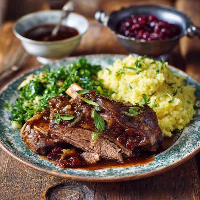 A beautifully plated roast of Mary Berry’s Rugby Lamb, sliced and served with golden potatoes, fresh herbs, and a rich gravy.