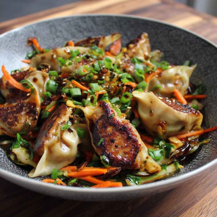 A colorful stir fry with crispy potstickers, sautéed vegetables, and a savory glaze, served in a wok and garnished with sesame seeds and green onions.