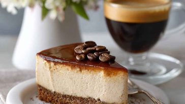Rich espresso cheesecake topped with a creamy garlic parmesan glaze, garnished with shaved chocolate and herbs on a rustic plate.