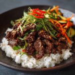Thinly sliced marinated Korean beef bulgogi grilled to perfection, served with sesame seeds, scallions, and steamed rice.