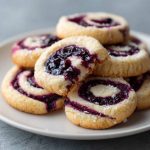 Blueberry cheesecake swirl cookies with marbled blueberry and cream cheese ribbons on a cooling rack.