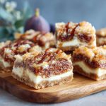 Fig and cream cheese dessert bars sliced on a tray with visible layers of fig jam and creamy filling.