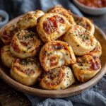 Golden New York-style pizza rolls stuffed with melted mozzarella, brushed with garlic butter, and served warm on a tray.