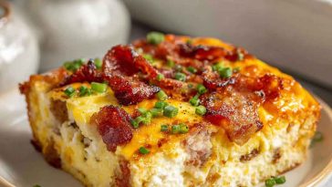 A golden-baked breakfast casserole filled with eggs, cheese, bacon, and hash browns, garnished with fresh herbs.