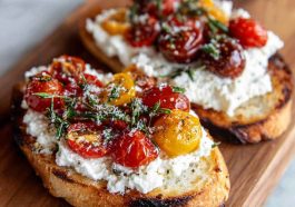 Sourdough toast topped with whipped ricotta, sliced cherry tomatoes, olive oil drizzle, and fresh basil leaves.