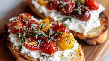 Sourdough toast topped with whipped ricotta, sliced cherry tomatoes, olive oil drizzle, and fresh basil leaves.