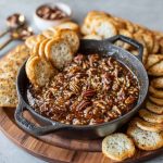 Creamy no bake pecan pie dip topped with caramel drizzle and chopped pecans, served with graham crackers.
