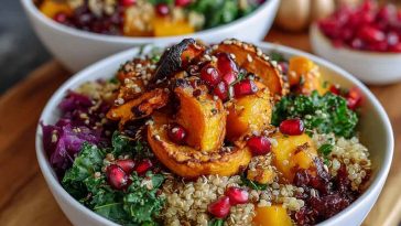 A bowl of autumn glow quinoa topped with roasted sweet potatoes, kale, chickpeas, and a drizzle of tahini dressing.