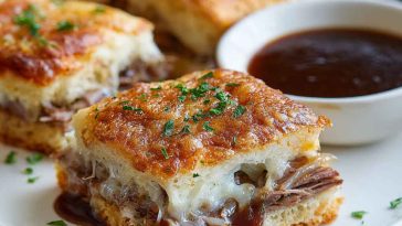 Golden baked French dip squares filled with roast beef, melted cheese, and served with au jus dipping sauce.