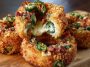 Golden-fried onion rings stuffed with jalapeño cream cheese filling, garnished with fresh herbs and served with dipping sauce.