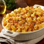 Southern-style baked mac and cheese with golden crust, creamy cheese sauce, and elbow pasta served in a casserole dish.