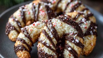 Magical candy cane cookies shaped with swirls of red and white dough, sprinkled with sugar, and arranged festively on a holiday plate.