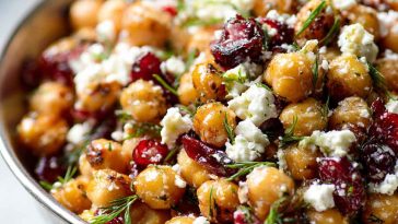 A colorful bowl of chickpeas tossed with crumbled feta, dried cranberries, fresh herbs, and lemon vinaigrette.