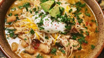 Alt Text: Bowl of Cajun white chicken chili topped with jalapeños, cilantro, and sour cream