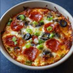 Low carb crustless pizza bowl filled with melted cheese, pepperoni, sausage, and fresh vegetables.