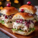 Mini Havarti cranberry turkey sliders with melted cheese, cranberry sauce, and golden slider buns served on a platter.
