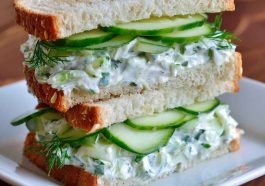 Fresh cucumber salad sandwiches layered with creamy spread, crisp cucumbers, and herbs, served on soft bread slices.