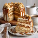 A layered caramel coffee buttercream cake with silky frosting, caramel drizzle, and chocolate shavings on top.