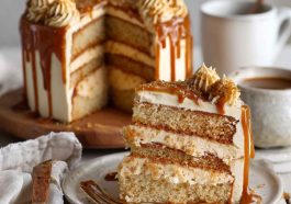 A layered caramel coffee buttercream cake with silky frosting, caramel drizzle, and chocolate shavings on top.