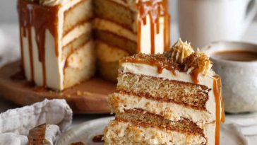 A layered caramel coffee buttercream cake with silky frosting, caramel drizzle, and chocolate shavings on top.