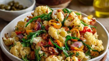 A colorful Sicilian cauliflower salad with roasted cauliflower florets, olives, capers, cherry tomatoes, and fresh parsley, drizzled with olive oil.