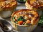 Mini pot pies filled with roasted autumn vegetables in a creamy sauce, topped with golden puff pastry and fresh thyme.