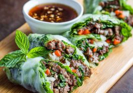 Rice paper rolls filled with Thai basil beef, cucumbers, and herbs, served with chili-lime dipping sauce.