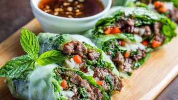 Rice paper rolls filled with Thai basil beef, cucumbers, and herbs, served with chili-lime dipping sauce.