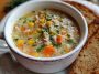 A steaming bowl of Amish Snow Day Soup filled with potatoes, vegetables, and creamy broth, garnished with fresh parsley.