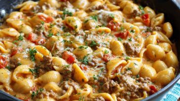 One-pot creamy beef and shells pasta topped with parmesan, served in a skillet with fresh herbs.