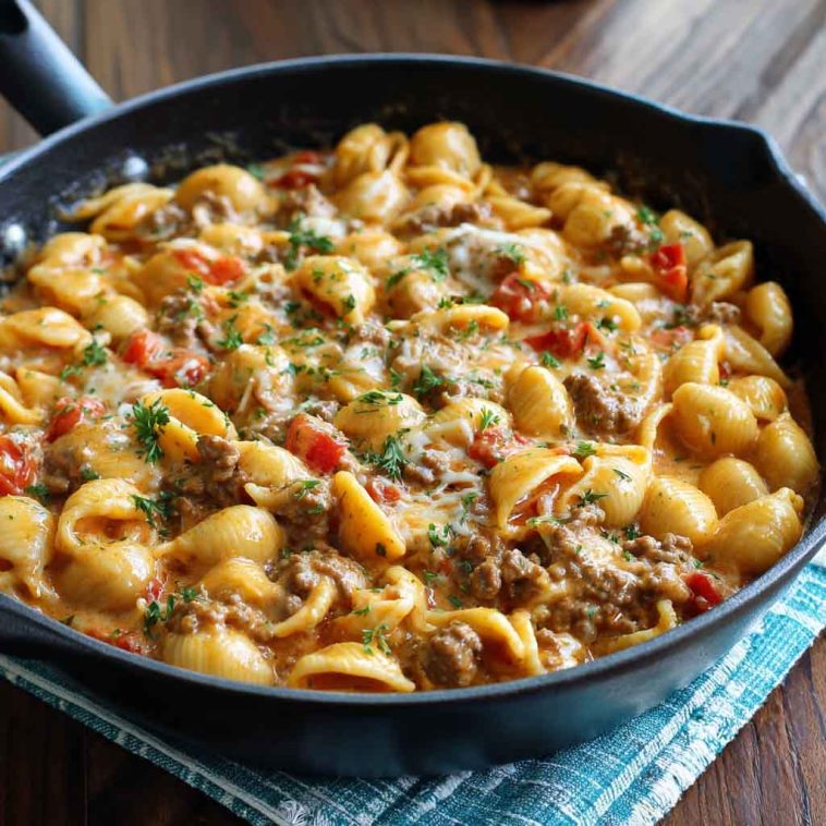 One-pot creamy beef and shells pasta topped with parmesan, served in a skillet with fresh herbs.