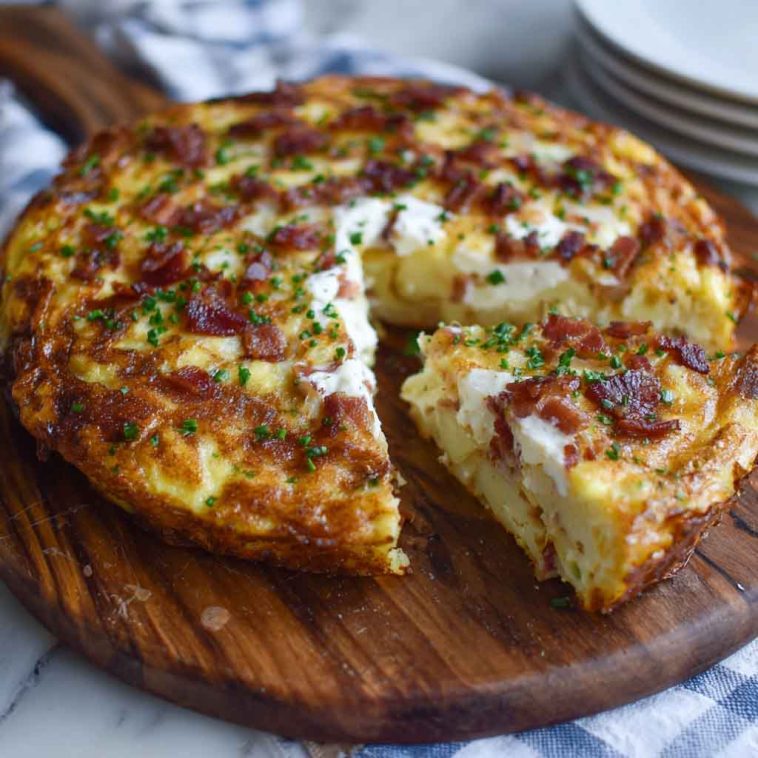 A golden-baked frittata filled with crispy bacon, tender Yukon Gold potatoes, and melted Gruyère cheese, garnished with scallions.