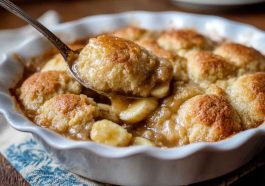 A golden-baked Southern banana cobbler with caramelized banana slices bubbling under a buttery crust, served with vanilla ice cream.
