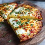 A golden, crispy cottage cheese pizza crust topped with tomato sauce, melted mozzarella, and fresh basil.