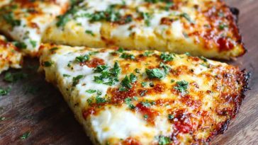 A golden, crispy cottage cheese pizza crust topped with tomato sauce, melted mozzarella, and fresh basil.