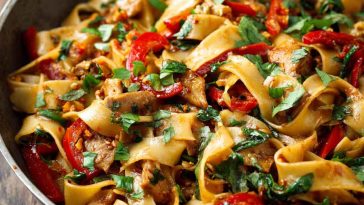 Colorful Thai drunken noodles stir-fried with wide rice noodles, fresh basil, vegetables, and savory sauce served in a wok.