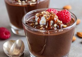 Glass jar of healthy chocolate pudding topped with berries and a sprinkle of cacao nibs.
