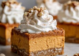 A tray of sweet potato pie bars with a golden crust, creamy spiced filling, and whipped cream topping.