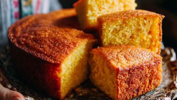 A golden slice of sweet potato butter cake with a moist crumb, topped with a buttery glaze and served on a vintage plate.